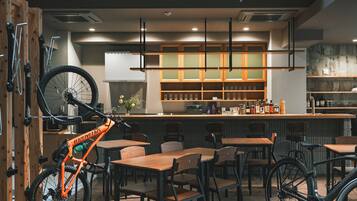 A restaurant interior with wooden furniture, a bar area, and a bicycle mounted on the wall.