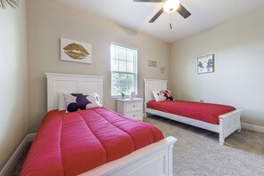 A bedroom with two beds, a window with blinds, a ceiling fan, and wall decorations. - 10 Mi to Disney & Old Town! Stylish Family Home (Kissimmee)