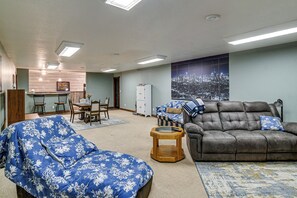Ein Wohnzimmer mit einer Couch, einem Esstisch mit Stühlen und einer Wand mit Stadtansicht.