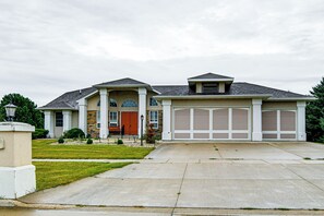 A two-story house with a front porch, a garage, and a well-maintained lawn.