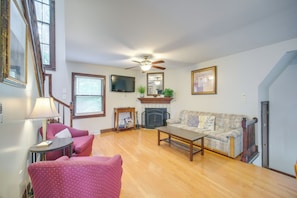 A living room with a fireplace, a sofa, a coffee table, and a television. - 6 Mi to Dtwn! Historic Haven in Cleveland (Cleveland)