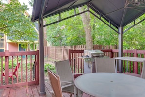 A covered outdoor seating area with a table and chairs, a grill, and a wooden fence. - 6 Mi to Dtwn! Historic Haven in Cleveland (Cleveland)