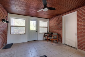 A room with a ceiling fan, two doors, a window, a chair, and a tiled floor. - Centrally Located Cincinnati Escape w/ Deck & Yard (Cincinnati)