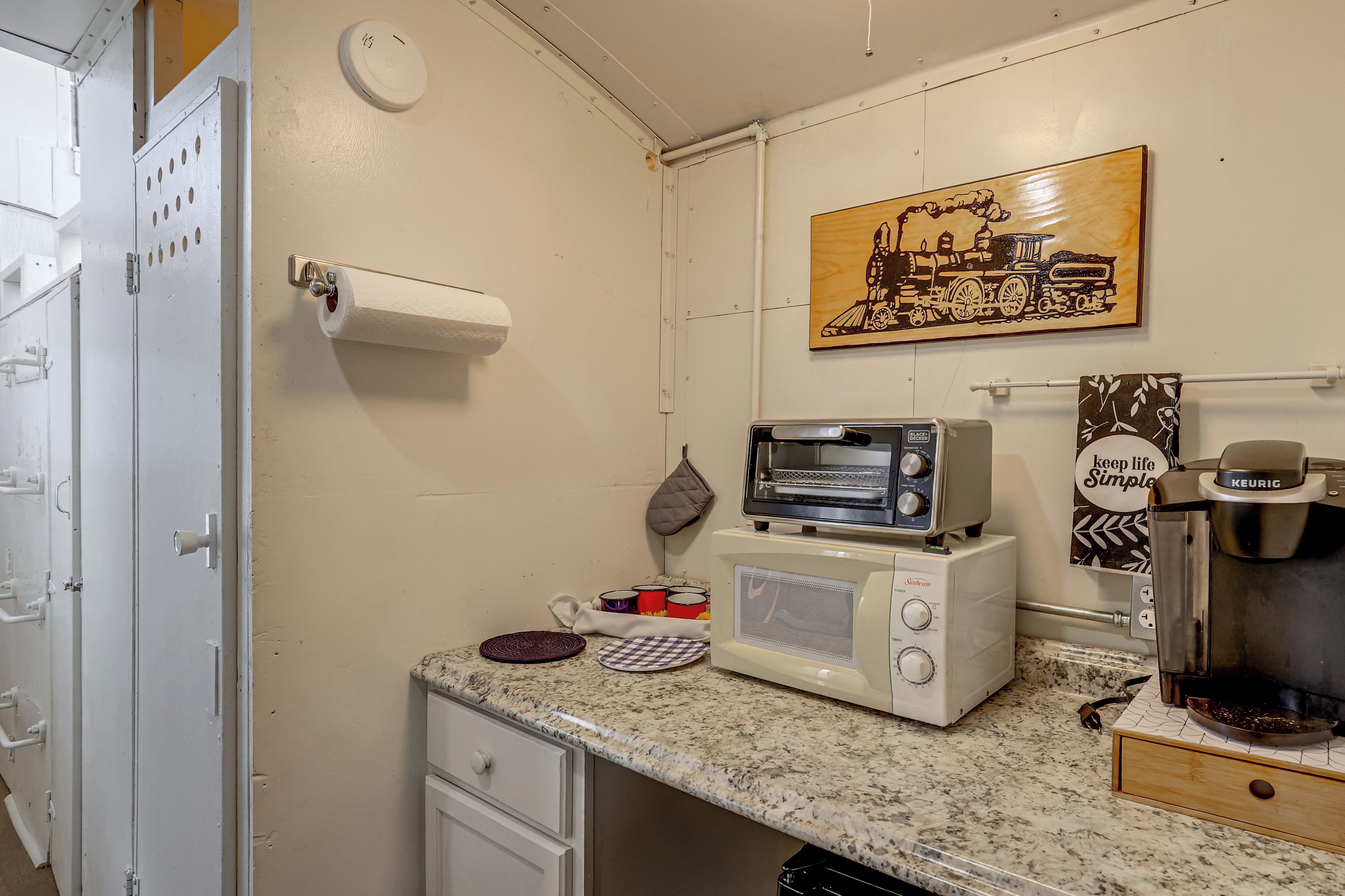 A compact kitchenette with a microwave, toaster, and coffee maker.