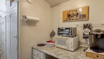 A compact kitchenette with a microwave, toaster, and coffee maker.