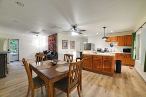 A modern kitchen with wooden cabinets, a dining area with a wooden table and chairs, and a ceiling fan. - Fall Foliage & Hot Tub Nights: Shawnee Cabin (Elizabethtown)