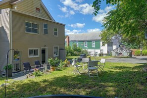 A two-story house with a front porch, outdoor seating, and a fenced yard. - Spacious Troy Unit Near Dtwn Shops & Dining (Troy)