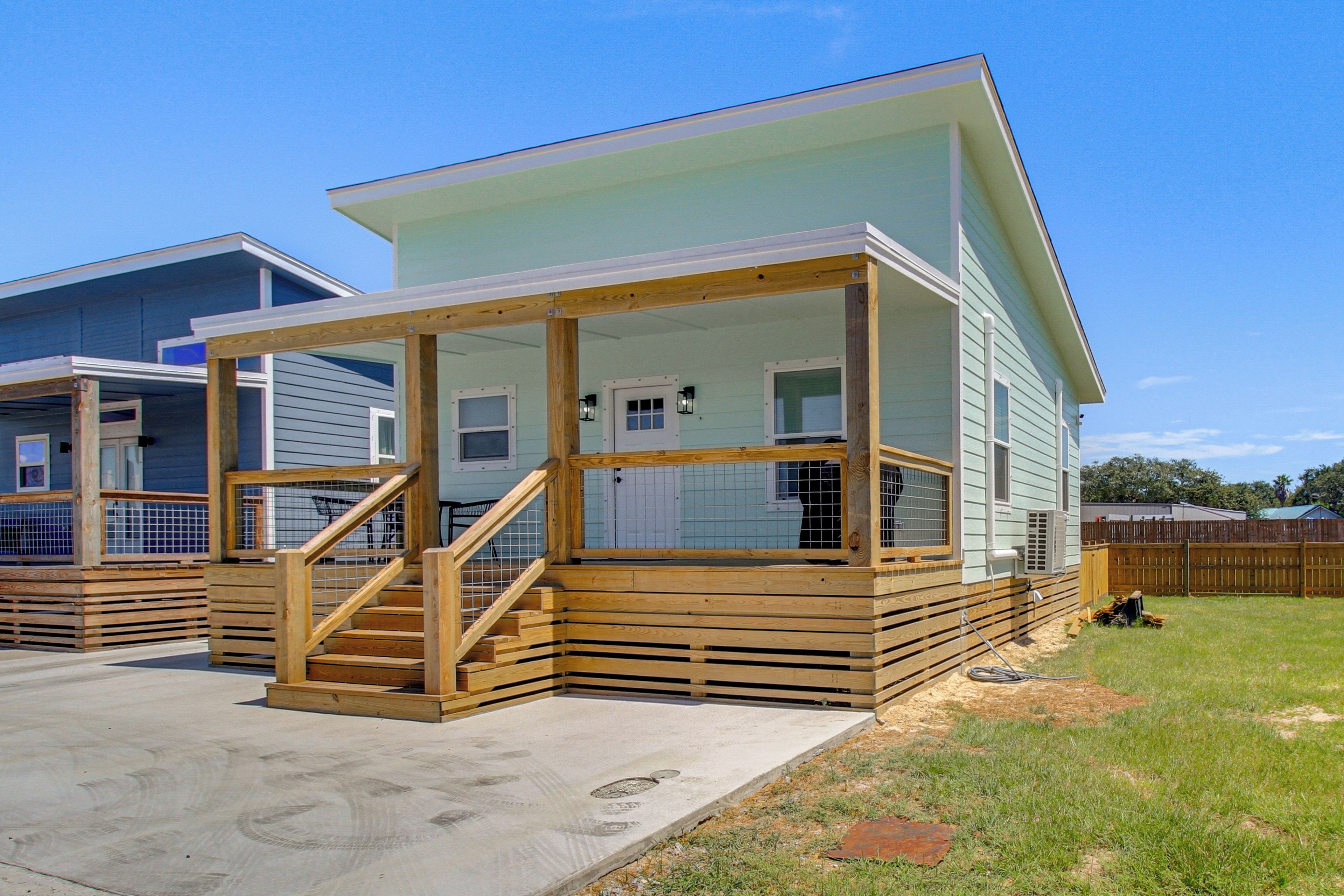 A two-story house with a covered porch and a wooden staircase.