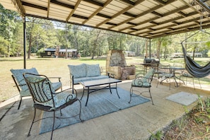 An outdoor patio with a covered seating area, a grill, and a hammock. - Boat Dock! Lakefront Family Retreat in Talladega (Talladega)