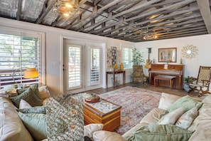 A cozy living room with a wooden ceiling, a piano, a sofa, and a coffee table. - Boat Dock! Lakefront Family Retreat in Talladega (Talladega)
