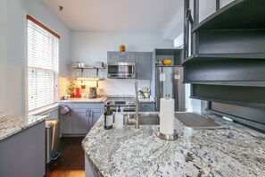 A modern kitchen with granite countertops, stainless steel appliances, and a window with blinds. - Walk to Waterfront! Old Town Alexandria Escape (Alexandria)