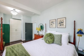 A bedroom with a bed, a dresser, a mirror, a lamp, and two framed pictures on the wall. - Walk to Waterfront! Old Town Alexandria Escape (Alexandria)
