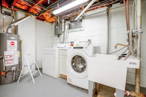 Ein Waschraum mit Waschmaschine, Trockner und Warmwasserbereiter.
