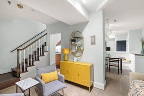 A modern living room with a staircase, a dining area, and a kitchen. - Walkable Old Town Retreat Near the Waterfront (Alexandria)