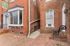 A red brick building with a white window, a black metal staircase, and a white door. - Walkable Old Town Retreat Near the Waterfront (Alexandria)