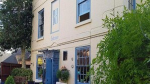 A building with a sign reading 'BH' and 'Entrance.' There are outdoor seating areas with tables and chairs. - Standard Double Room (Derby)
