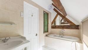 A bathroom with a white door, a bathtub, a sink, and a mirror. - Standard Double Room (Derby)