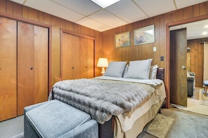 Ein Schlafzimmer mit einem Bett, einem Nachttisch, einer Lampe und einem Holzschrank.