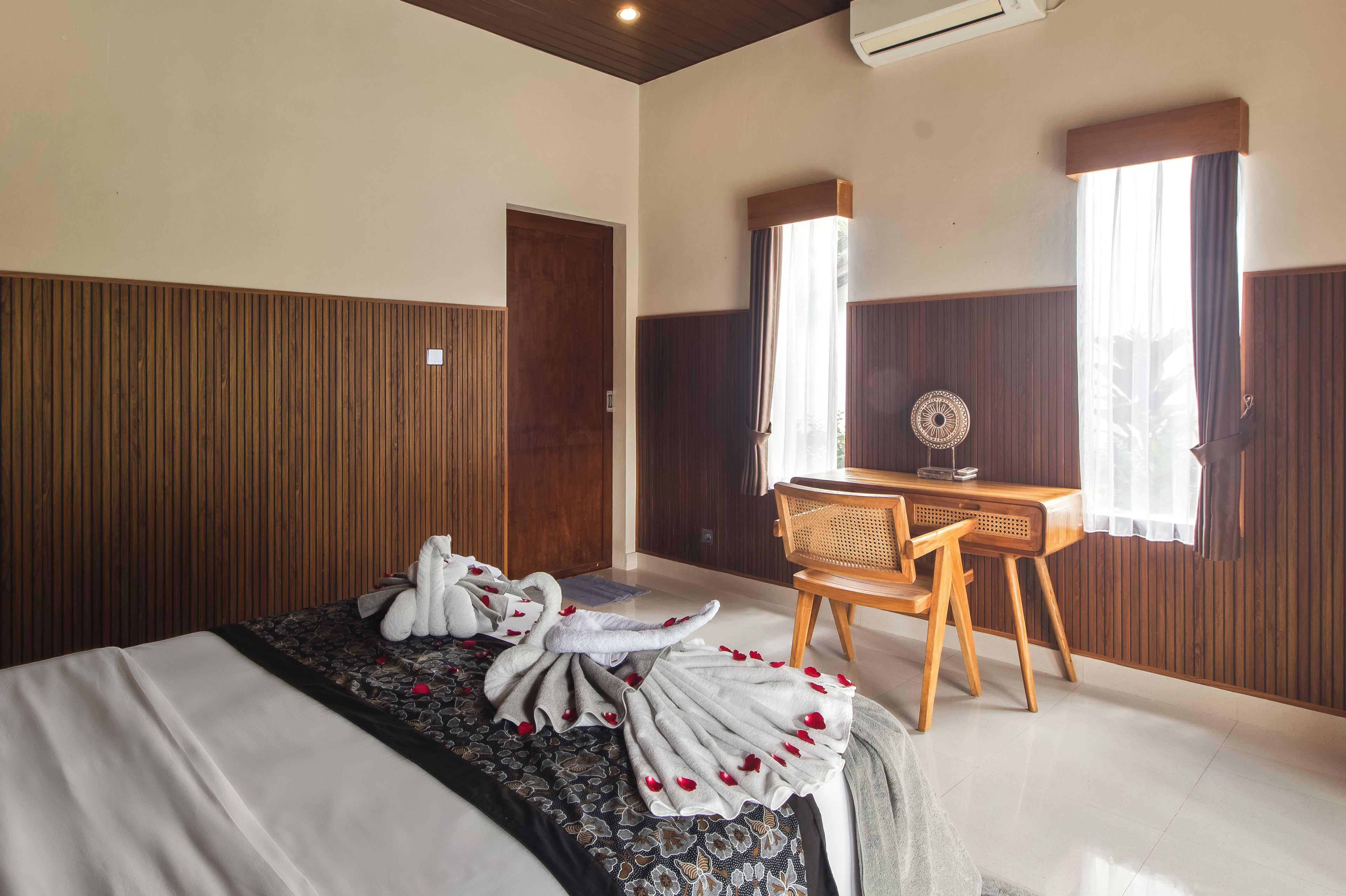 Una habitación de hotel con una cama, un escritorio y una silla.