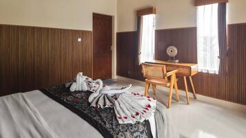 Una habitación de hotel con una cama, un escritorio y una silla.