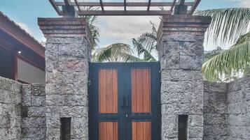 Un muro de piedra con una puerta de madera y un portón de metal.