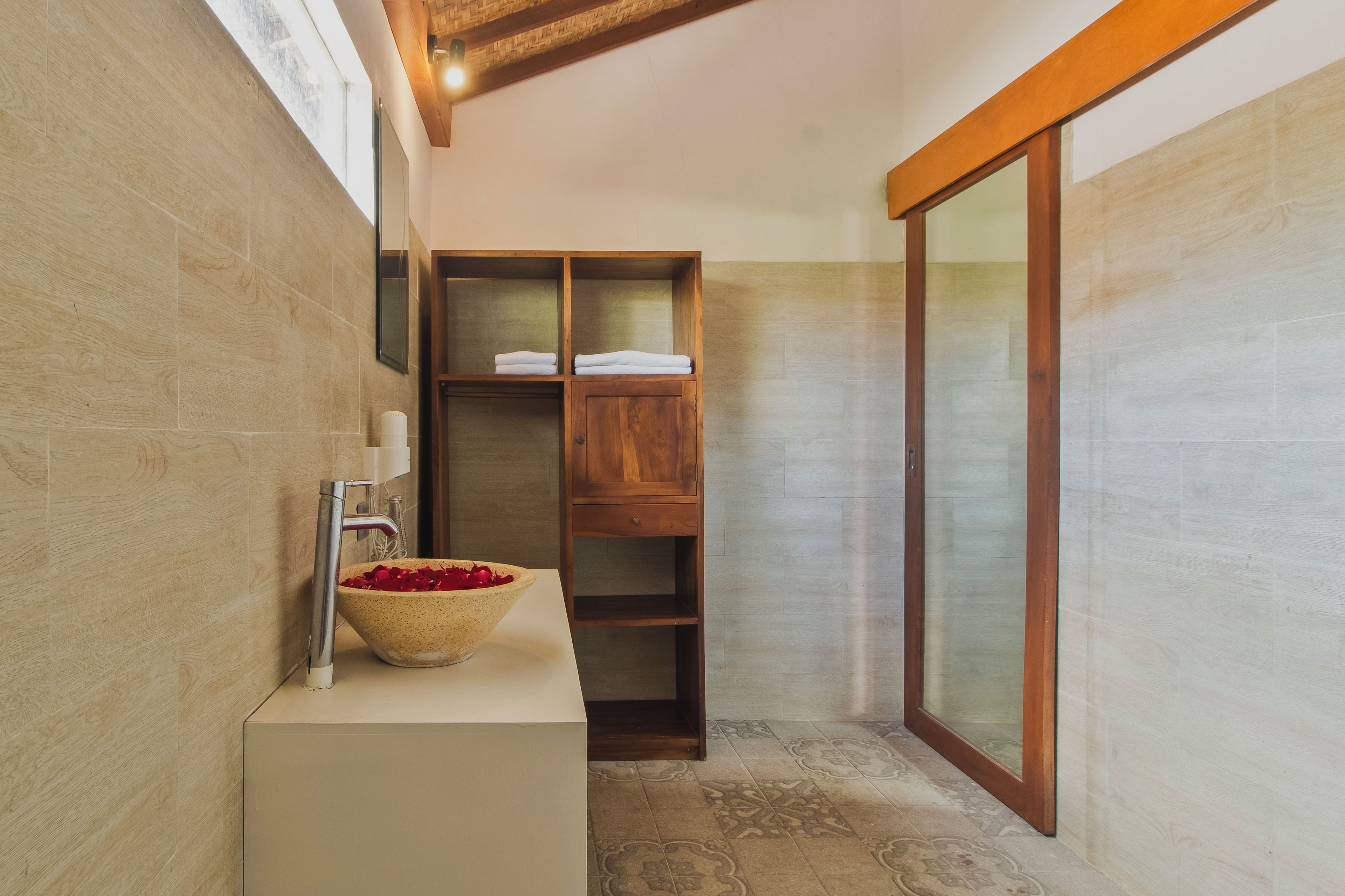 Un bagno con un mobile vanitario in legno, un lavabo e uno specchio grande.