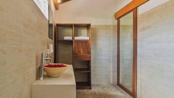 Un bagno con un mobile vanitario in legno, un lavabo e uno specchio grande.