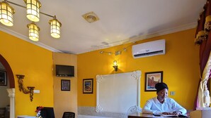 A hotel reception area with a reception desk, a television, and a decorative wall. - Quiet Pols Residence  (Lagos)