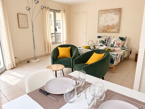 Un'area pranzo con un tavolo imbandito per quattro persone, sedie e una lampada da terra.