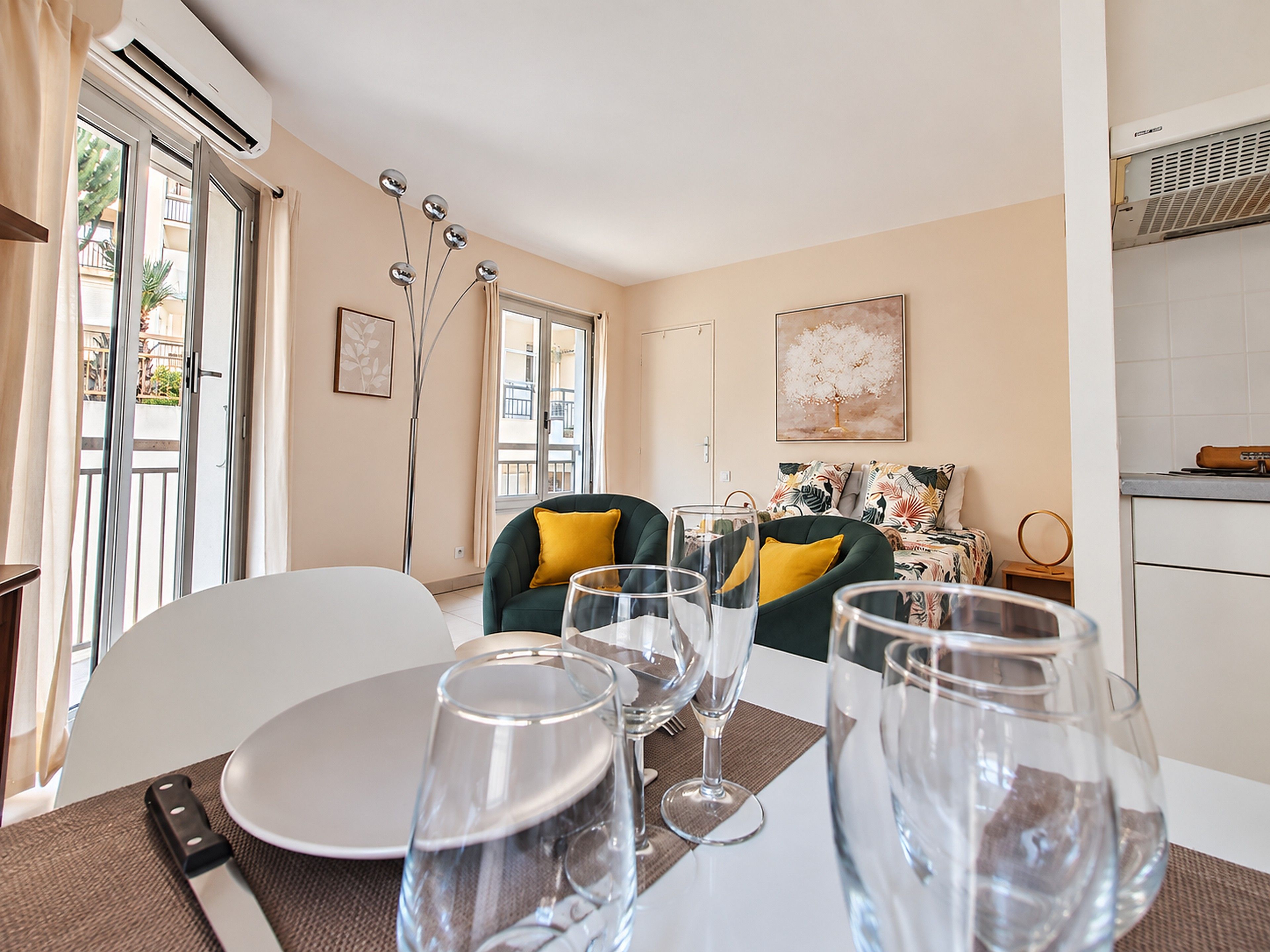 A dining area with a table set for four, including wine glasses and cutlery.