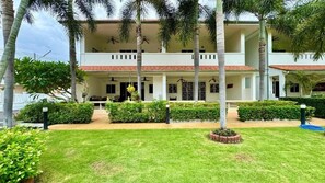 A hotel with a two-story structure, a covered outdoor area, and a well-maintained lawn. - 2BR Condo Near City Center (NG430) (Hua Hin)