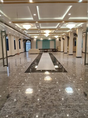 A spacious hotel lobby with a marble floor, a central seating area, and multiple ceiling lights. - RS Resort (Tahrauli)