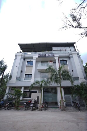 Un edificio de hotel moderno con un letrero que dice 'Perfect Hotel'.