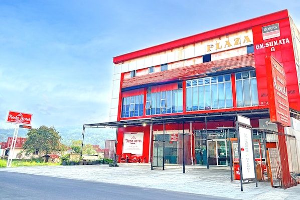 Un bâtiment rouge avec une enseigne indiquant « Korea Plaza » et un magasin GM Sumata.