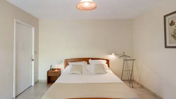 Une chambre à coucher avec un lit en bois, une table de chevet, une lampe de table et une lampe sur pied.