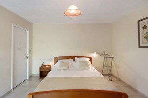 Une chambre à coucher avec un lit en bois, une table de chevet, une lampe de table et une lampe sur pied.