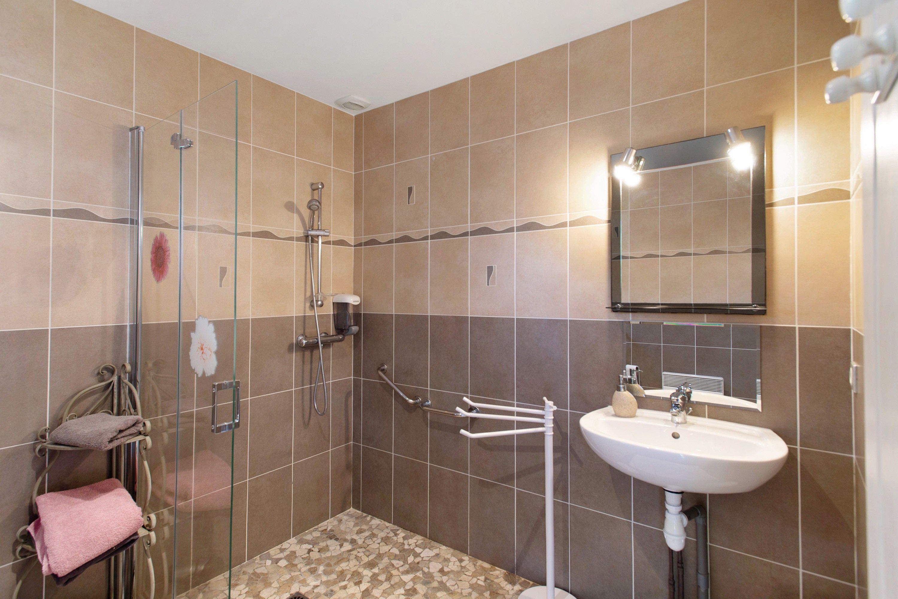 Un baño con ducha, lavamanos y espejo.
