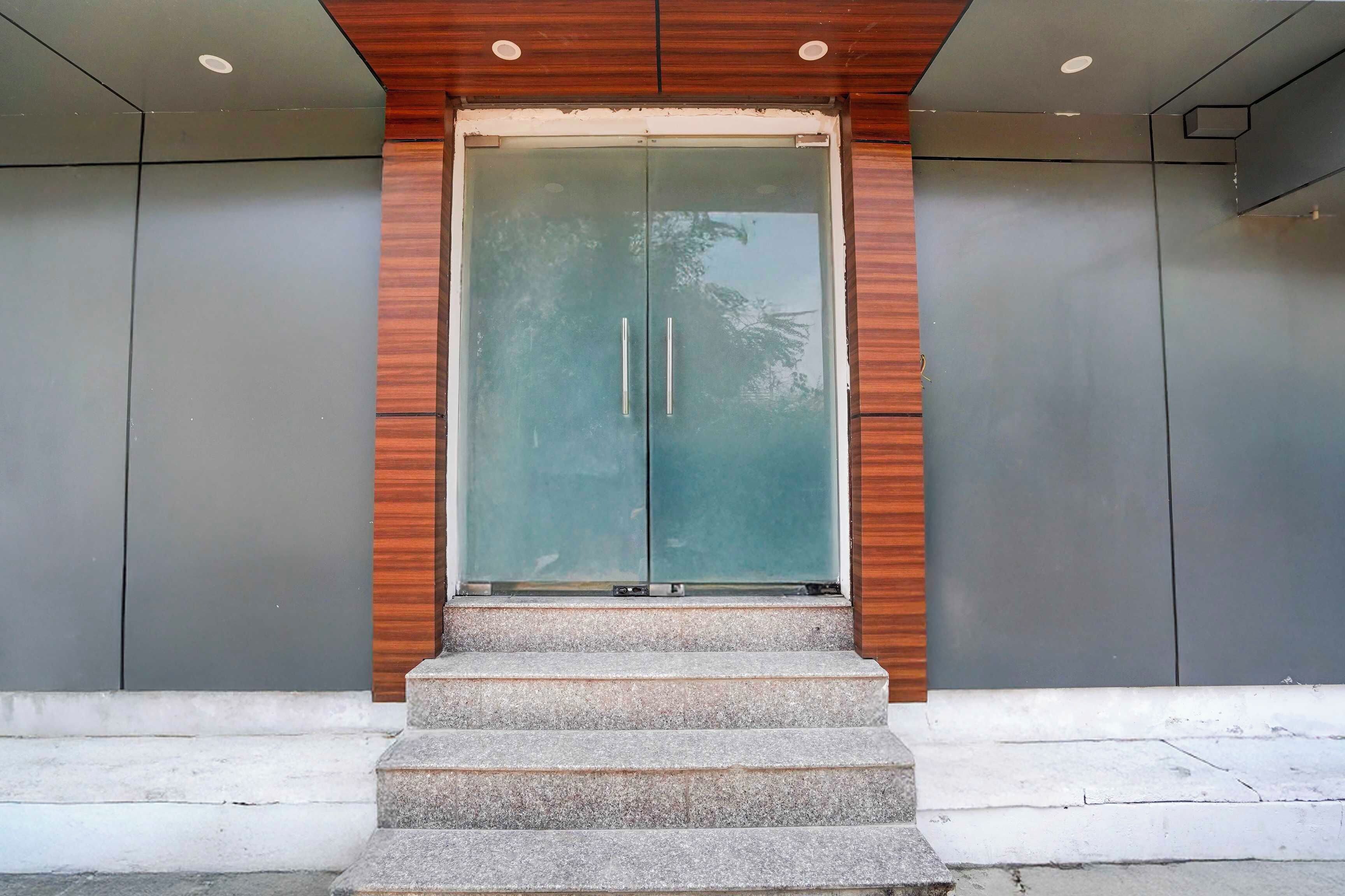 A modern building entrance with a glass door and wooden paneling.