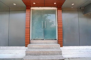 Una entrada de edificio moderna con puerta de vidrio y paneles de madera.