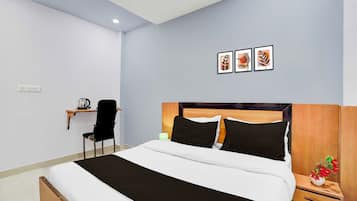 Un dormitorio con cama, mesita de noche, lámpara, silla y estante en la pared con una tetera.