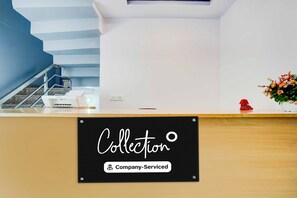 A reception desk with a sign that reads 'Collection Company-Serviced.' - Collection O Gomti Nagar Near Amity (Lucknow)
