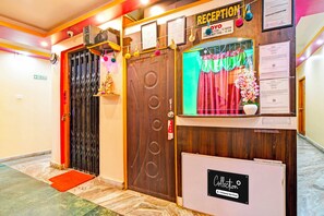 A reception area with a wooden door, a reception desk, and a sign indicating check-in times. - Collection O Kolkata Jagannath Temple (Shrirampur)