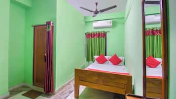 Un dormitorio con cama, armario, ventilador de techo y unidad de aire acondicionado.