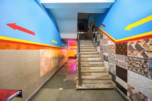 A corridor with directional arrows on the walls, a staircase with patterned tiles, and a tiled floor. - Collection O Kolkata Jagannath Temple (Shrirampur)