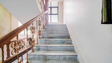 Una escalera con escalones de mármol y barandillas de metal decoradas.
