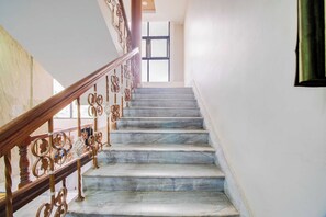 Una escalera con escalones de mármol y barandillas de metal decoradas.