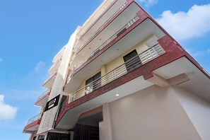 A multi-story hotel with balconies and a sign indicating it is a company-owned hotel. - Hotel O Sector 23 Udyog Vihar (Gurugram)
