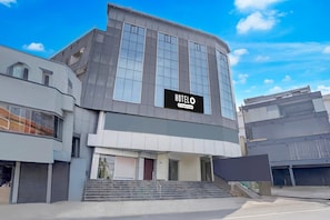A modern hotel building with a prominent sign, a staircase leading to the entrance, and a clear sky. - Hotel O Magunta Layout Nellore (Nellore)