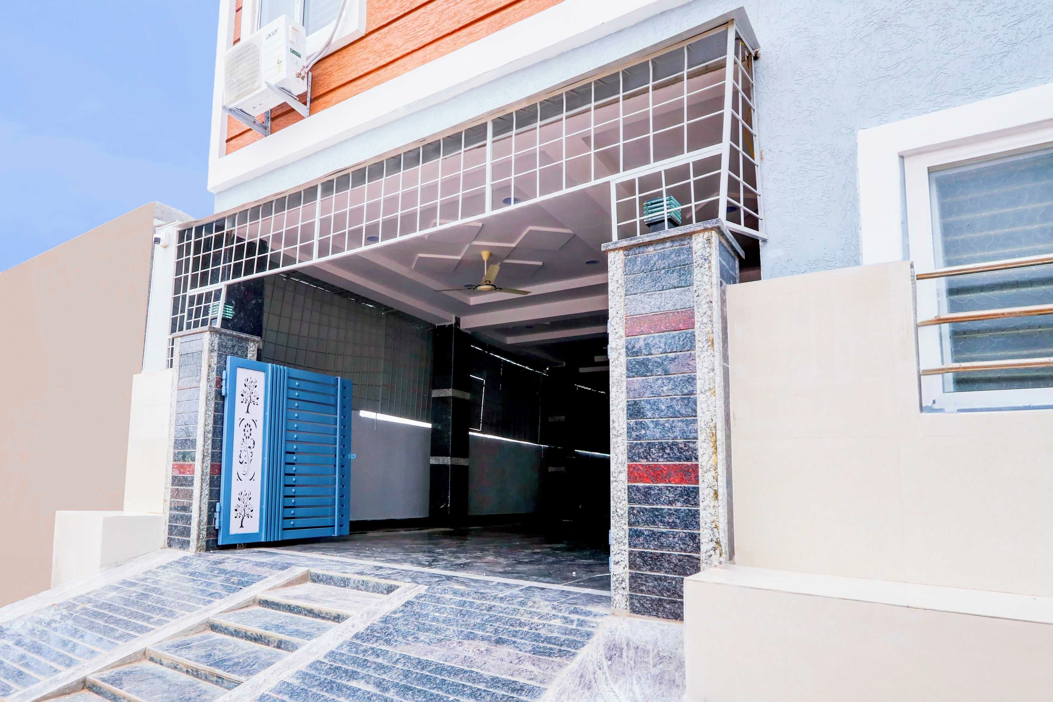 A building entrance with a blue door, a staircase, and a ceiling fan.
