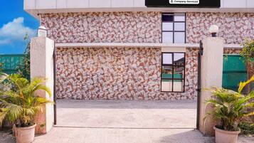A building with a distinctive marbled facade, a clear entrance, and potted plants at the entrance.